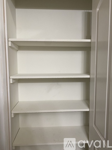 Empty white shelves in a cabinet.
