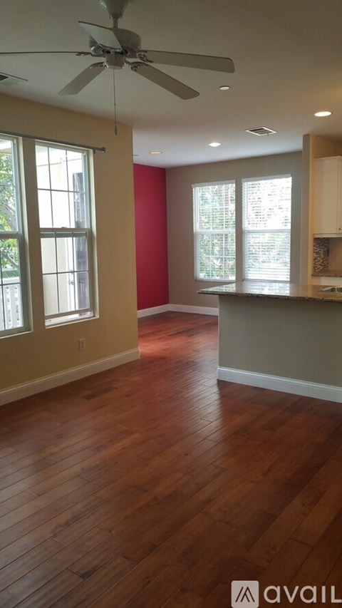 A room with wooden floors and a ceiling fan.