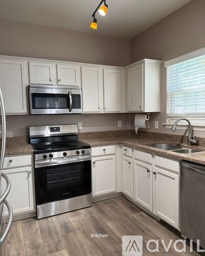 A kitchen with white cabinets and a stainless steel oven.