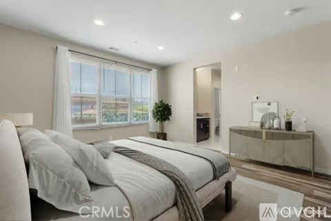 A bedroom with a large bed and a window with a view of the outside.