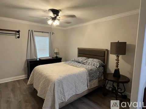 A bedroom with a bed, nightstand, and a ceiling fan.