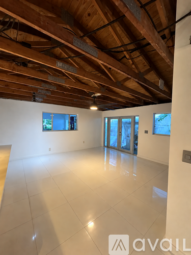 A spacious room with wooden ceiling and white walls.