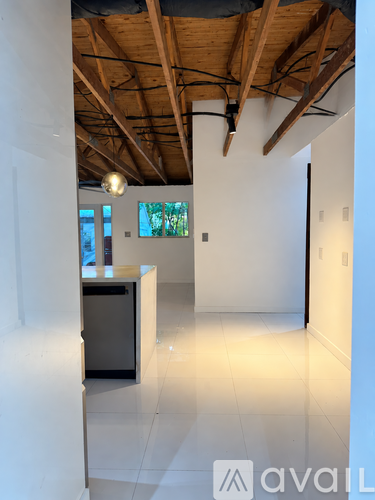 A room with a wooden ceiling and a white wall with a counter on it.