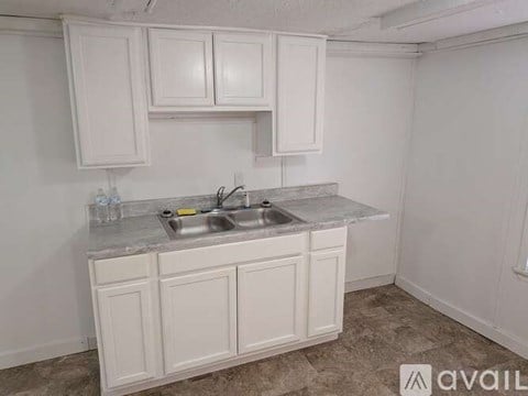 A kitchen with white cabinets and a granite countertop.