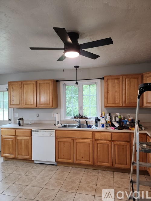 A kitchen with wooden cabinets and a white dishwasher.