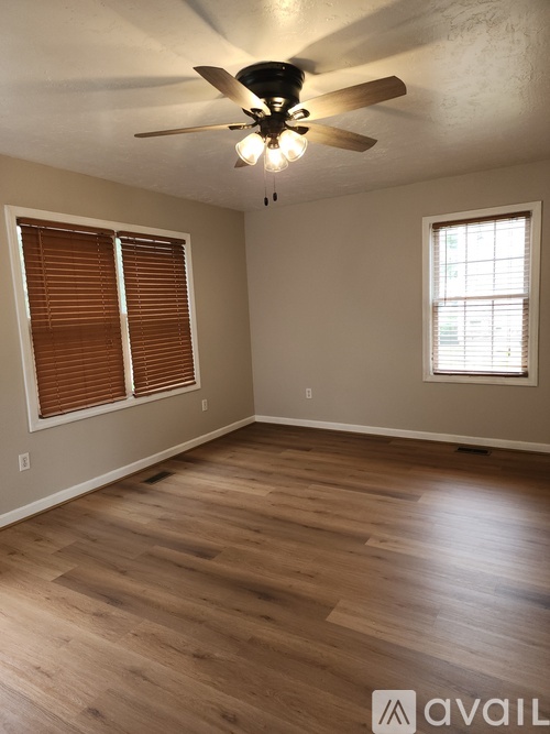 A room with wooden floors and a ceiling fan.