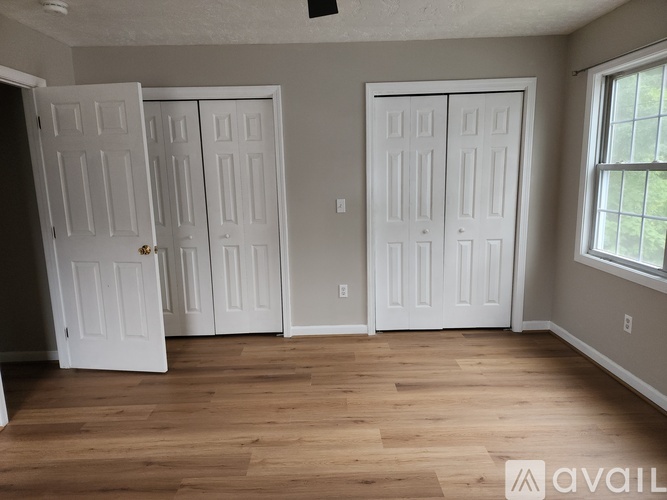 A room with wooden floors and white doors.