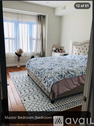 A bedroom with a bed and a hat on a stand.