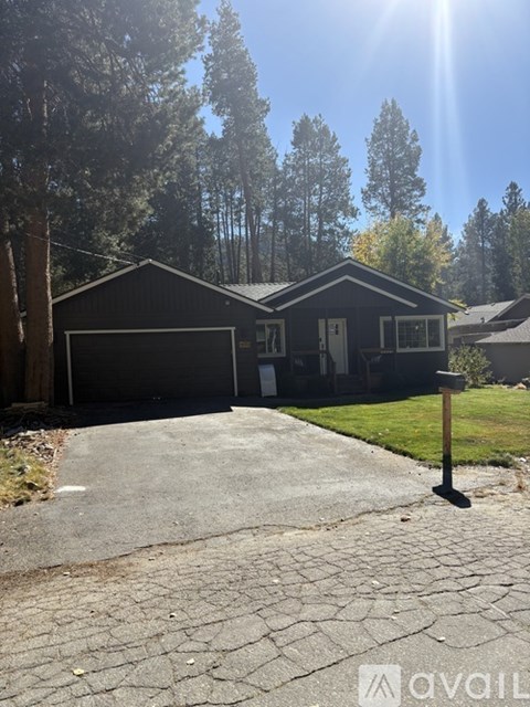 A house with a garage and a driveway in front of it.