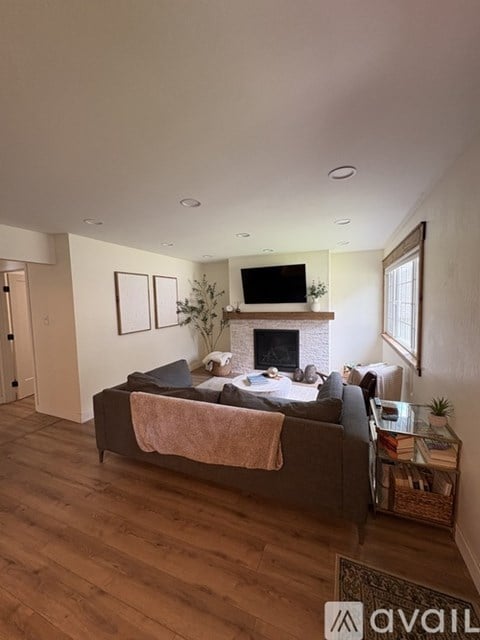 A living room with a couch, a fireplace, and a television.