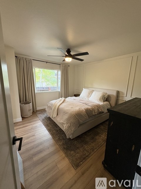 A bedroom with a bed, dresser, and window.