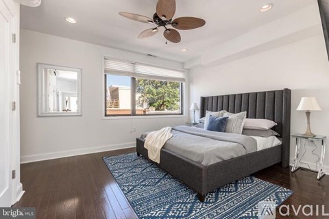 A bedroom with a large bed and a ceiling fan.