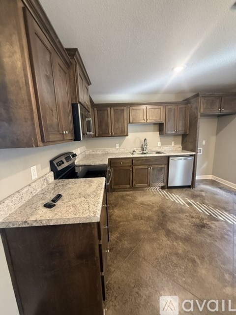 A kitchen with brown cabinets and a granite countertop.