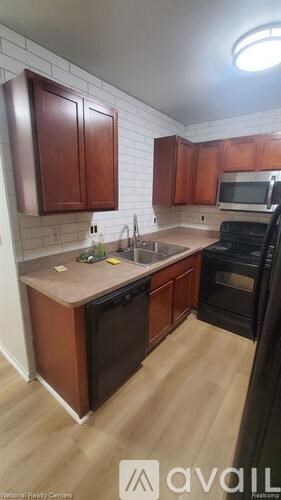 A kitchen with wooden cabinets and a black oven.