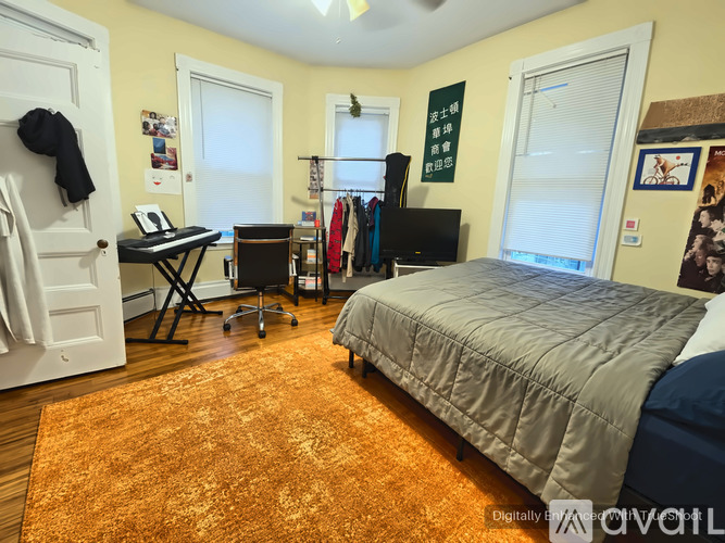A bedroom with a bed, desk, and closet.