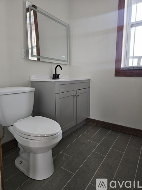 A white toilet sits next to a sink in a bathroom.