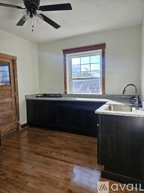 A kitchen with a black counter and a window.