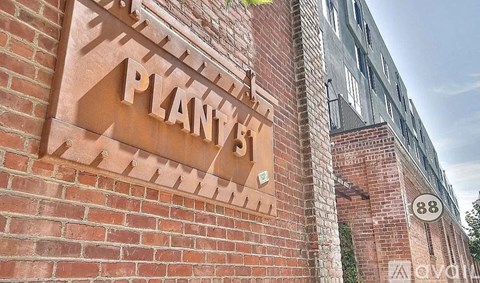 A brick wall with a sign that says "Planty's" on it.