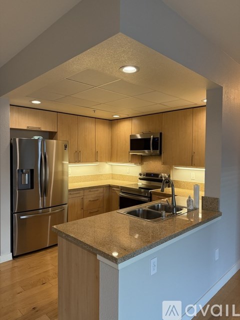 A kitchen with a granite countertop and stainless steel appliances.