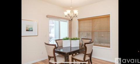 A dining room with a table and chairs.