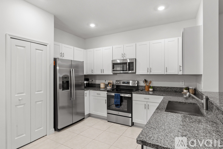 A kitchen with white cabinets and a granite countertop.