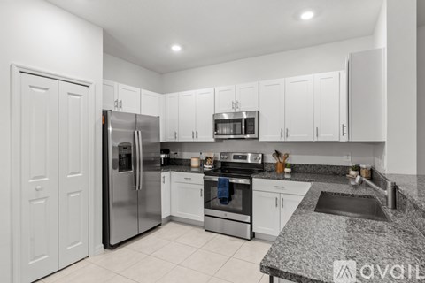 A kitchen with white cabinets and a granite countertop.