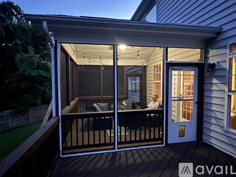 A person is sitting on a couch inside a house through a glass door.