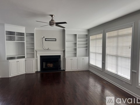 A living room with a fireplace and a fan.