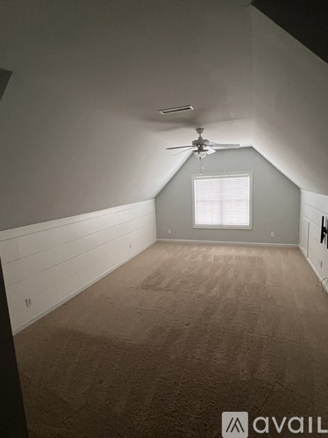 A room with a ceiling fan and a window.
