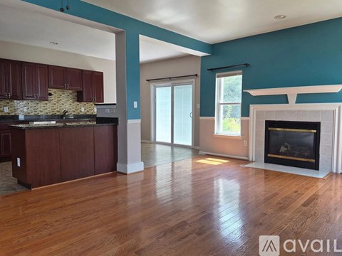 A spacious living room with a fireplace and hardwood floors.