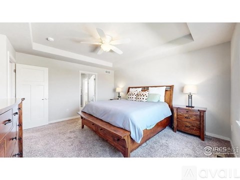 A bedroom with a large bed and a ceiling fan.