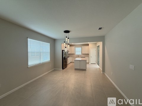 A spacious kitchen with a refrigerator, sink, and cabinets is available for rent.