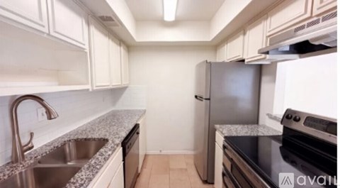 A kitchen with a stainless steel refrigerator and a black oven.