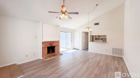 A living room with a fireplace and a ceiling fan.