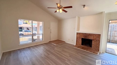 A room with a fireplace and a ceiling fan.