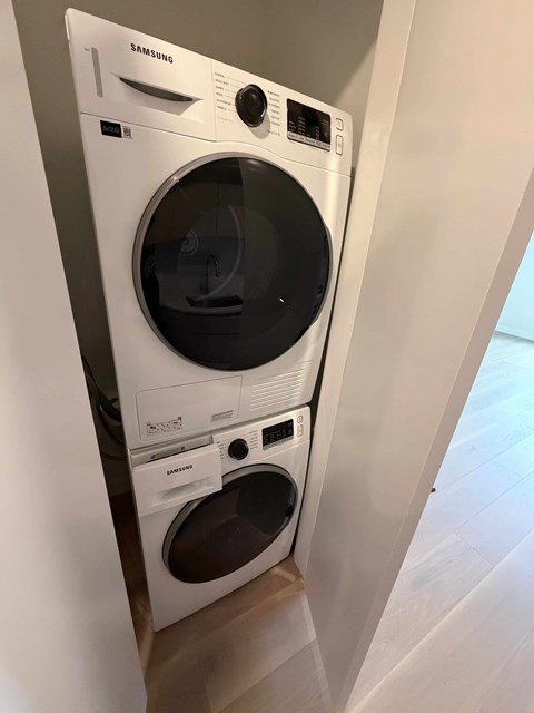 A white Samsung washing machine and dryer stacked on top of each other.
