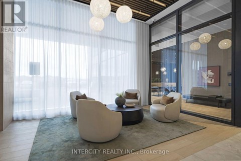 A modern living room with white furniture and a glass door leading to a balcony.