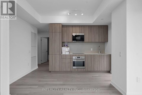 A modern kitchen with wooden cabinets and stainless steel appliances.