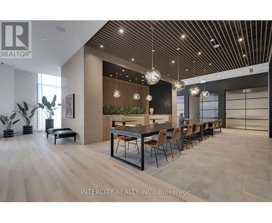 A modern dining room with a long table and chairs.