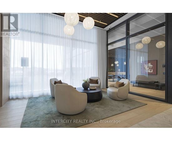 A modern living room with white furniture and a glass door leading to a balcony.