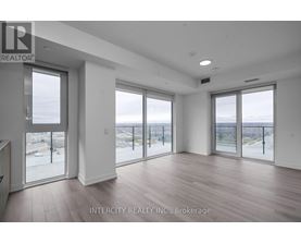 A spacious room with large windows overlooking a beach.