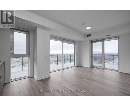 A spacious room with large windows overlooking a beach.