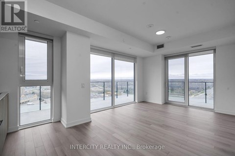 A spacious room with large windows overlooking a beach.