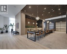 A modern dining room with a long table and chairs.