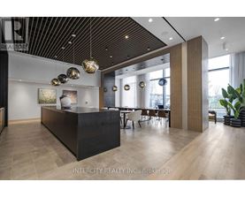 A modern office space with a black reception desk and wooden flooring.