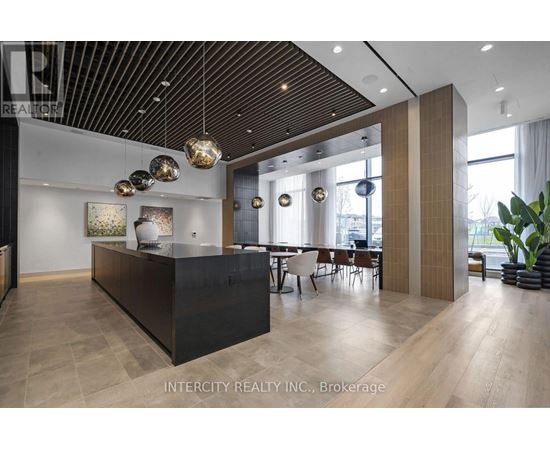 A modern office space with a black reception desk and wooden flooring.