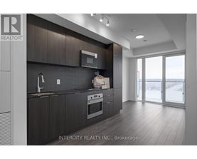 A modern kitchen with dark wood cabinets and stainless steel appliances.