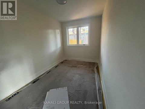A room with a window and a tarp on the floor.