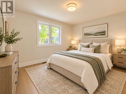 A bedroom with a bed, nightstands, and a window.