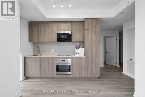 A kitchen with wooden cabinets and a stainless steel oven.